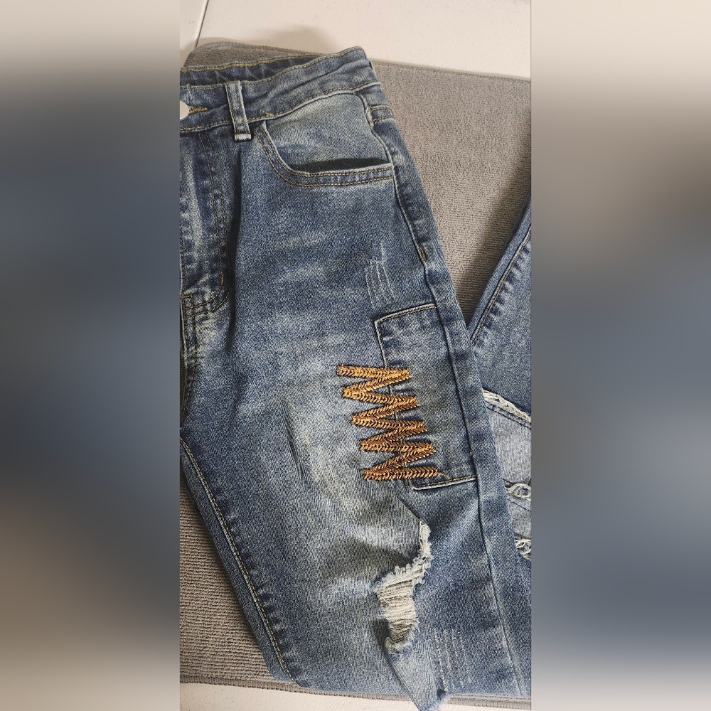 Stylish Distressed Blue Jeans with Gold Accents
